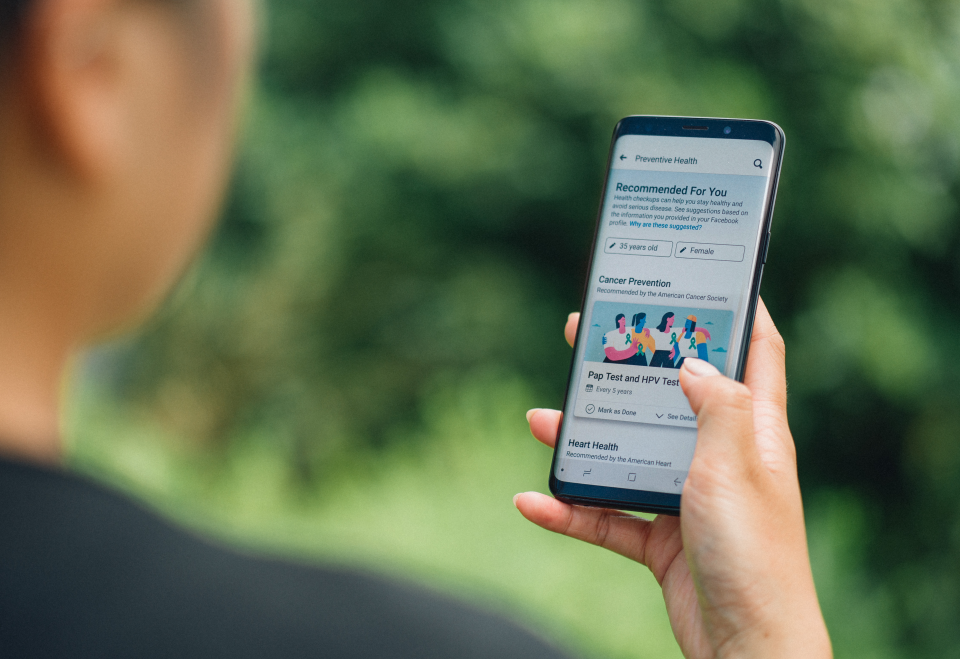 Person holding a phone using Preventive Health feature