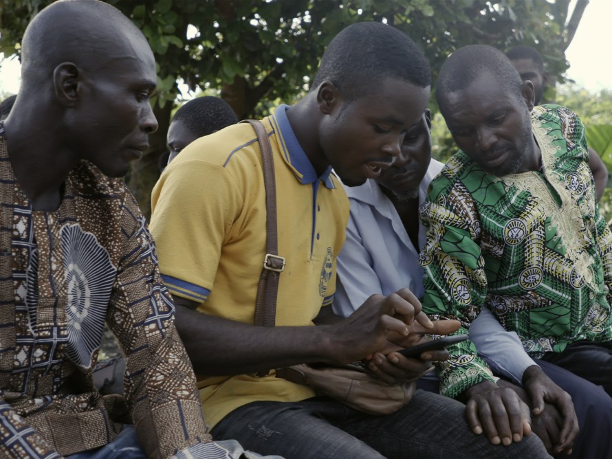 Four men looking at a mobile phone