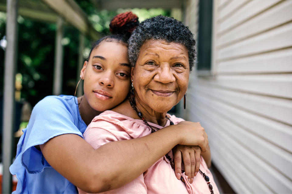 Photo of a girl embracing her grandmother