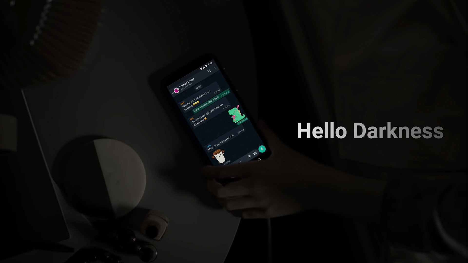 Screenshot of WhatsApp dark mode video (a hand reaching for a phone in a dark room)