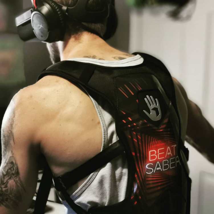 Photo of a gamer wearing Beat Saber SUBPAC and VR headset