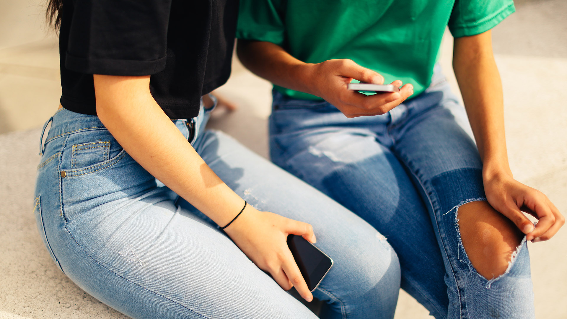 Photo of two teenagers looking at a phone