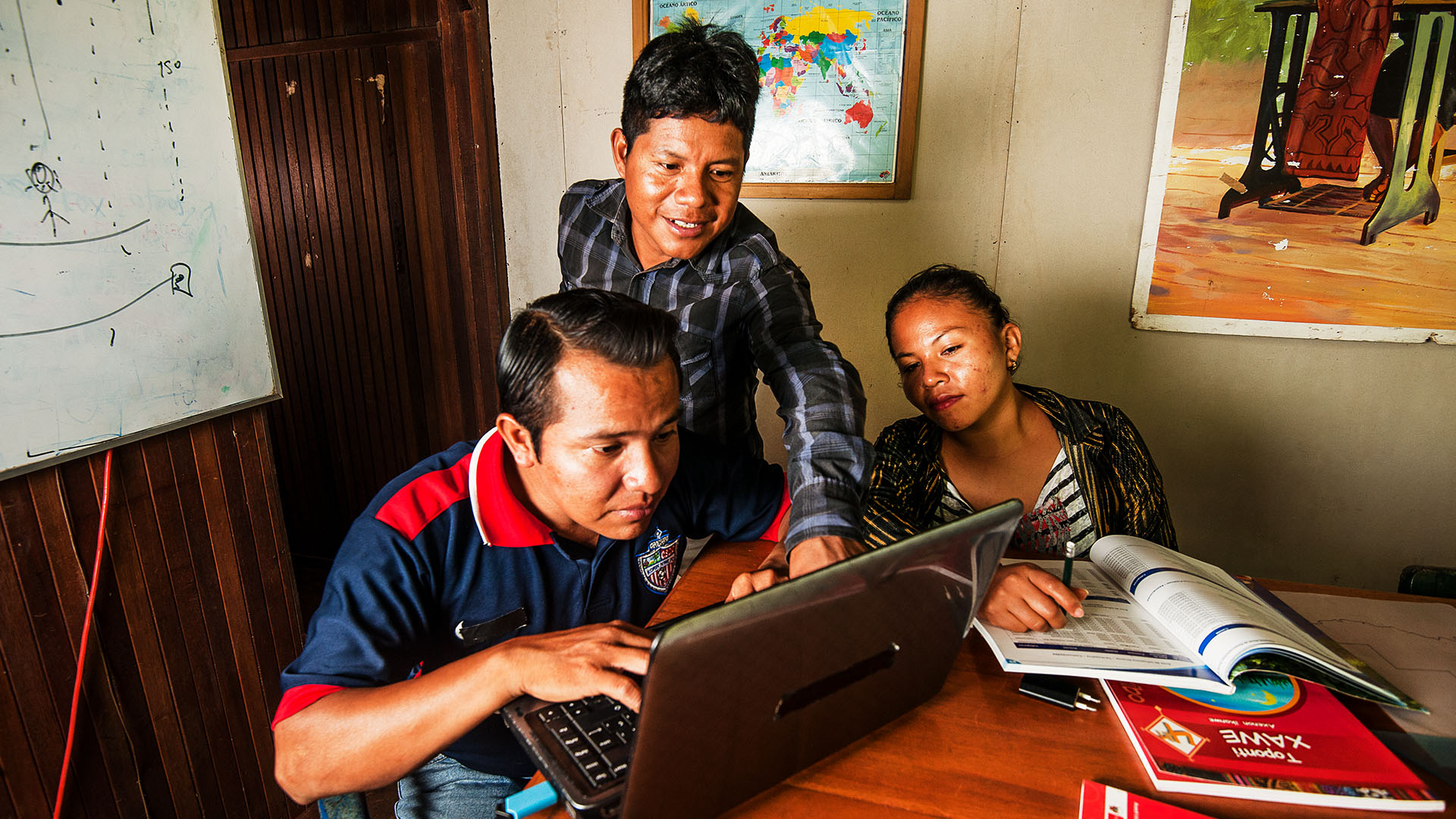 Three people working together at a computer