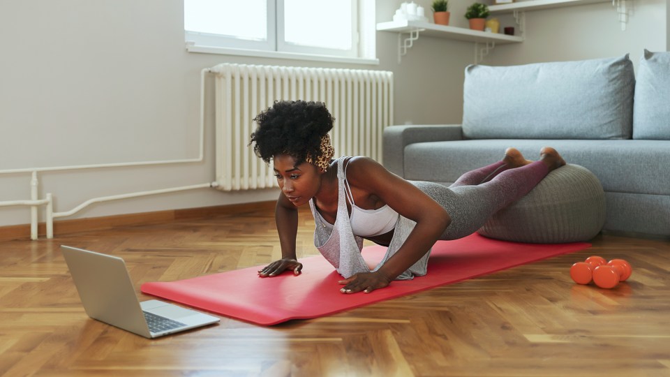 woman doing yoga in front of computer