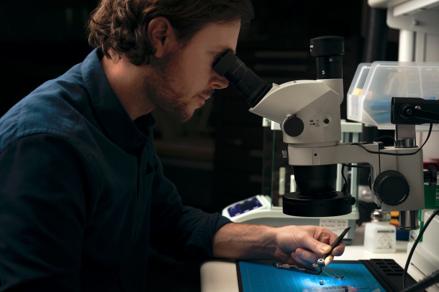 Researcher looks through microscope