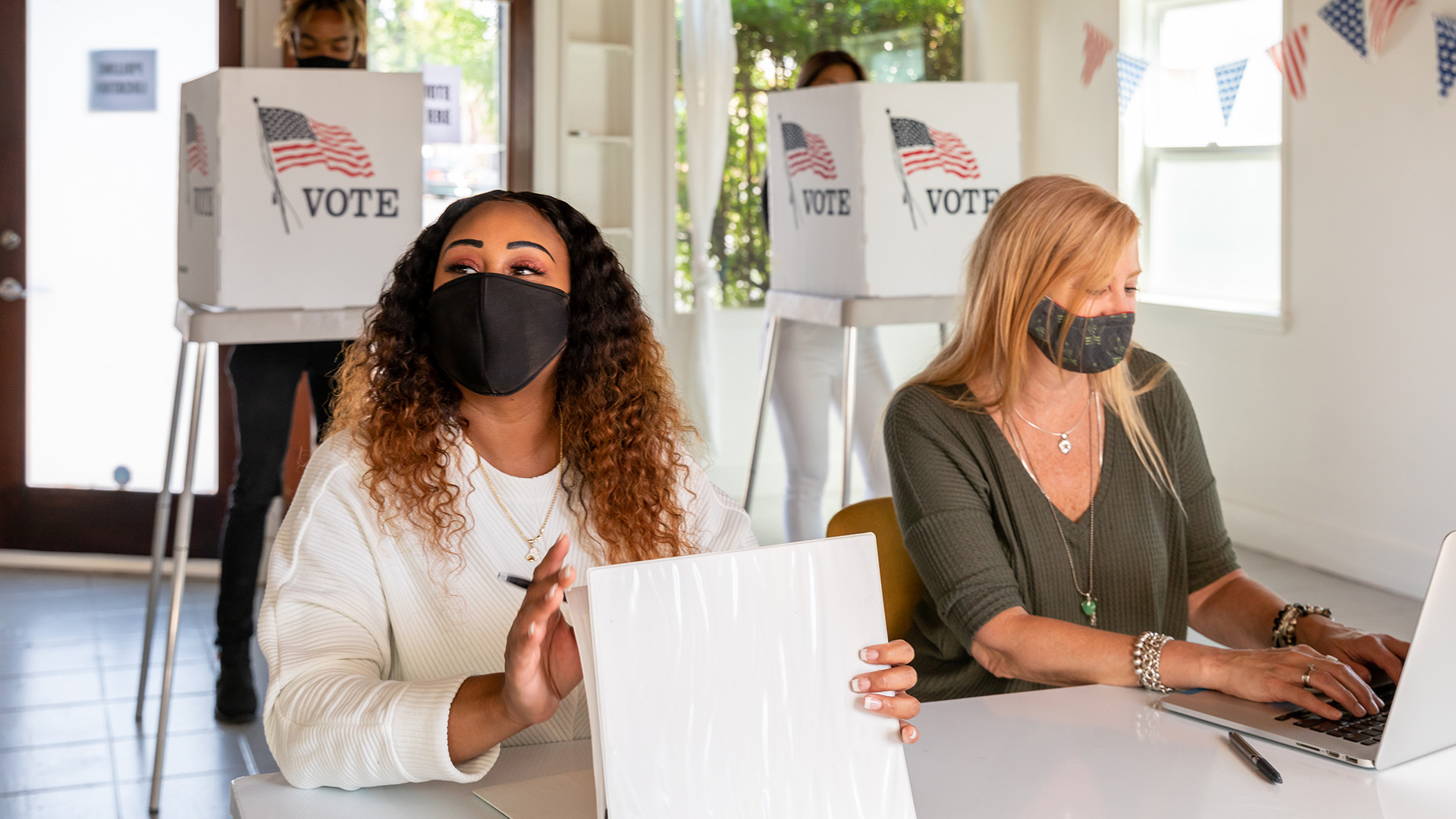 two women working at the polls