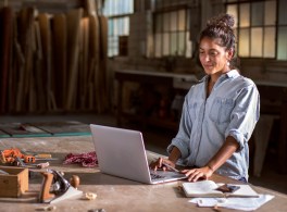 woman using a laptop in a woodshop