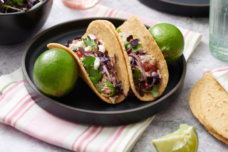 Tacos and limes on a plate.