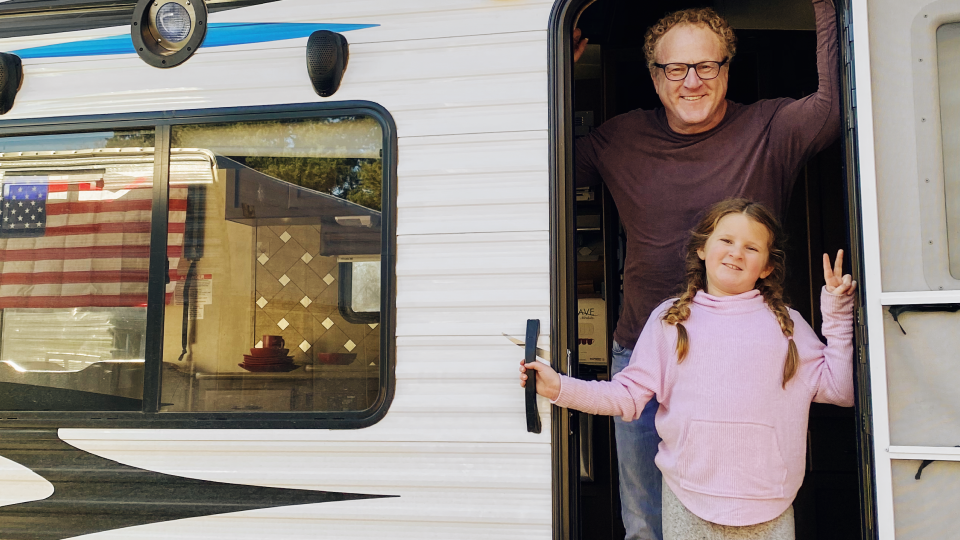 Photo of Woody Faircloth and his daughter posing in the doorway of an RV.