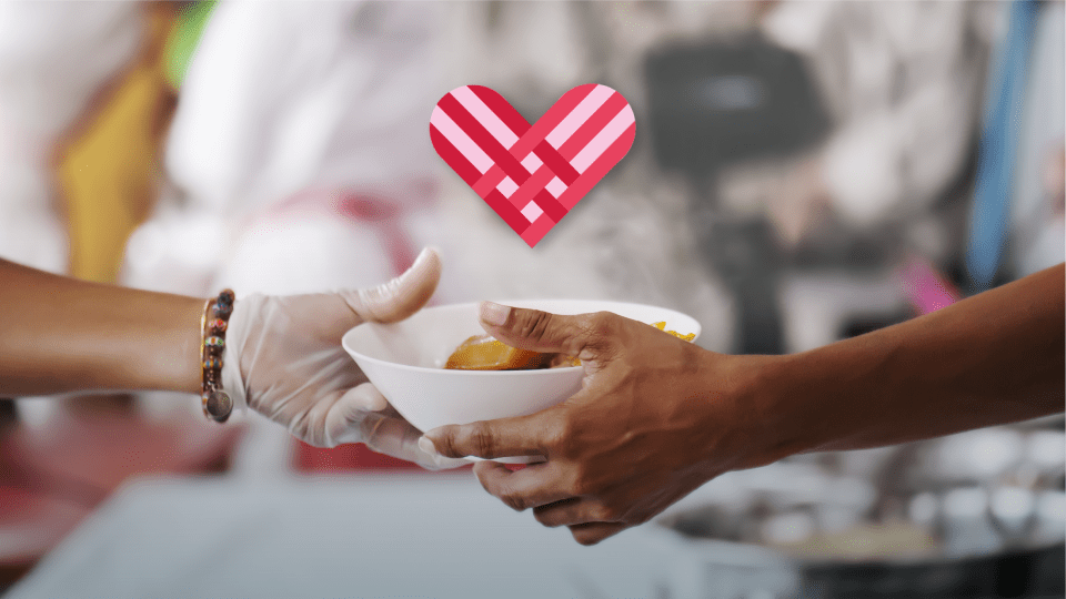 Photo of a person handing a bowl of food to another person.