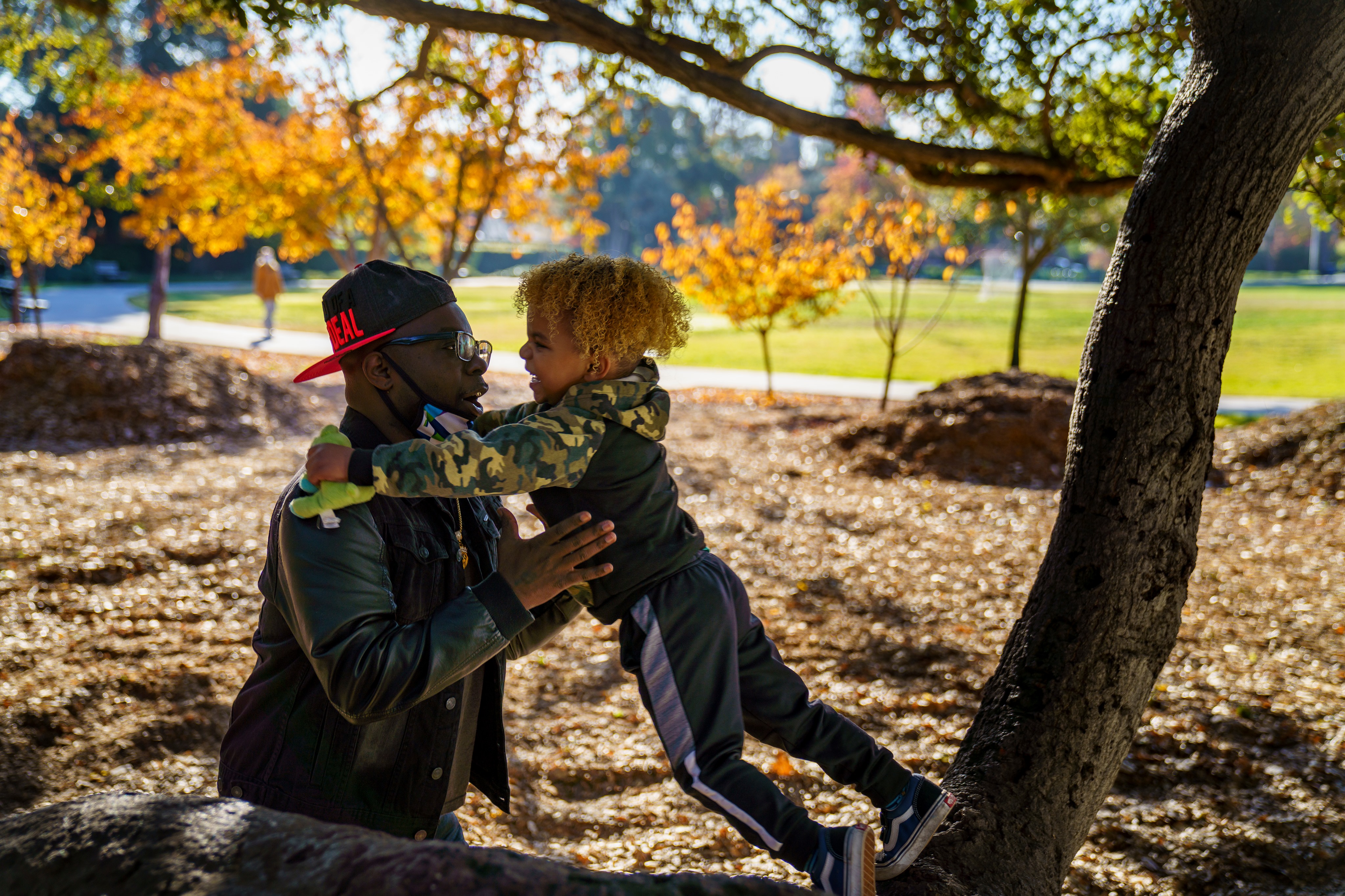 Man and son playing near a tree