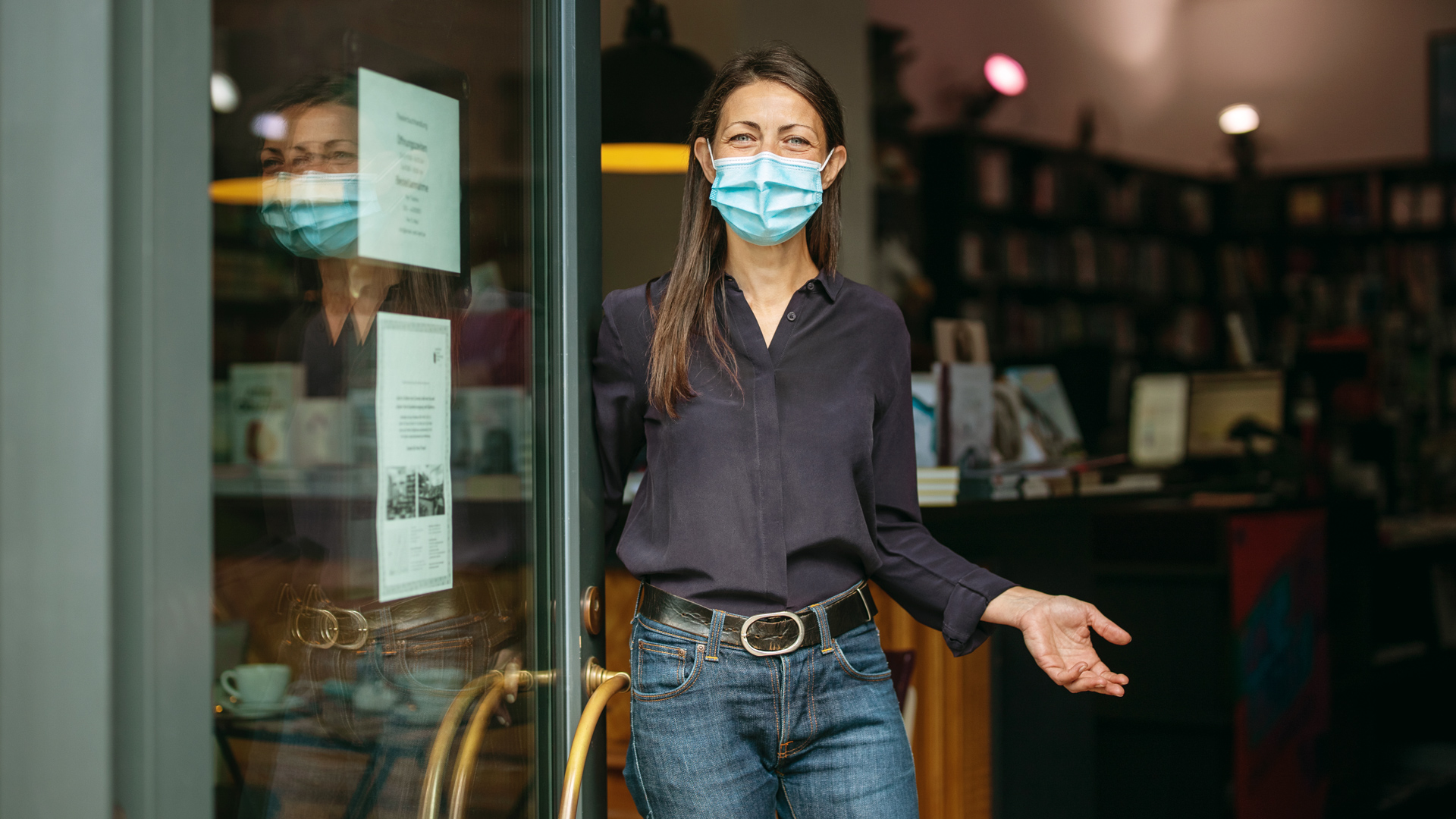 Picture of a woman in front of store wearing a mask