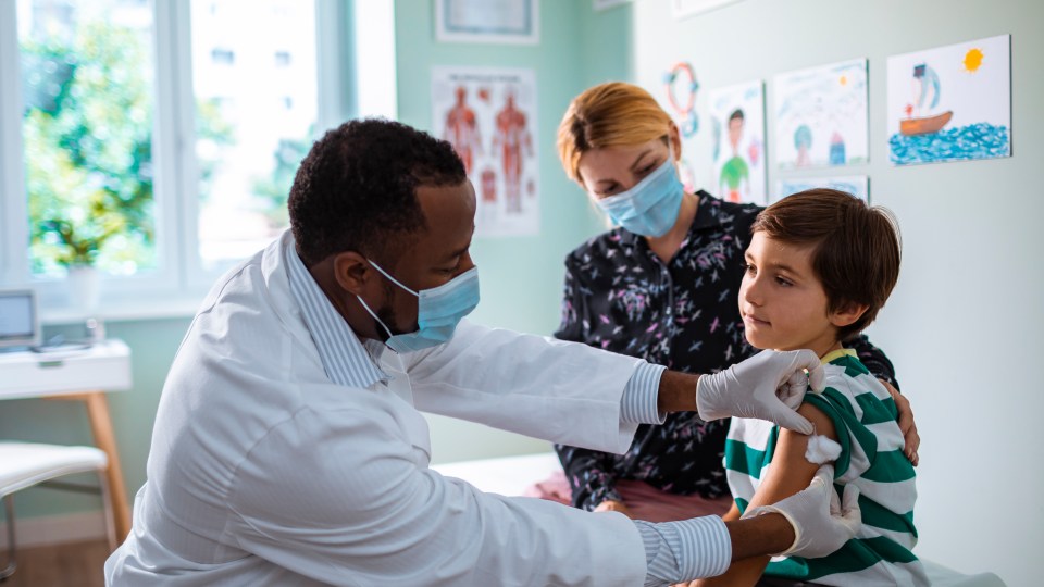 photo of a child being vaccinated by a doctor