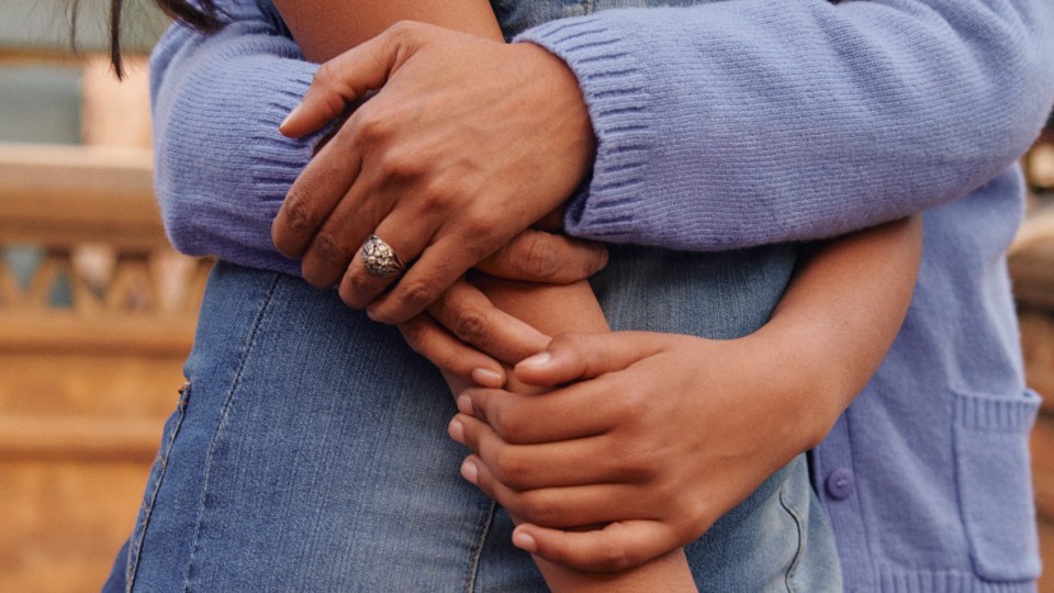 Photo of one woman's arms wrapped around another