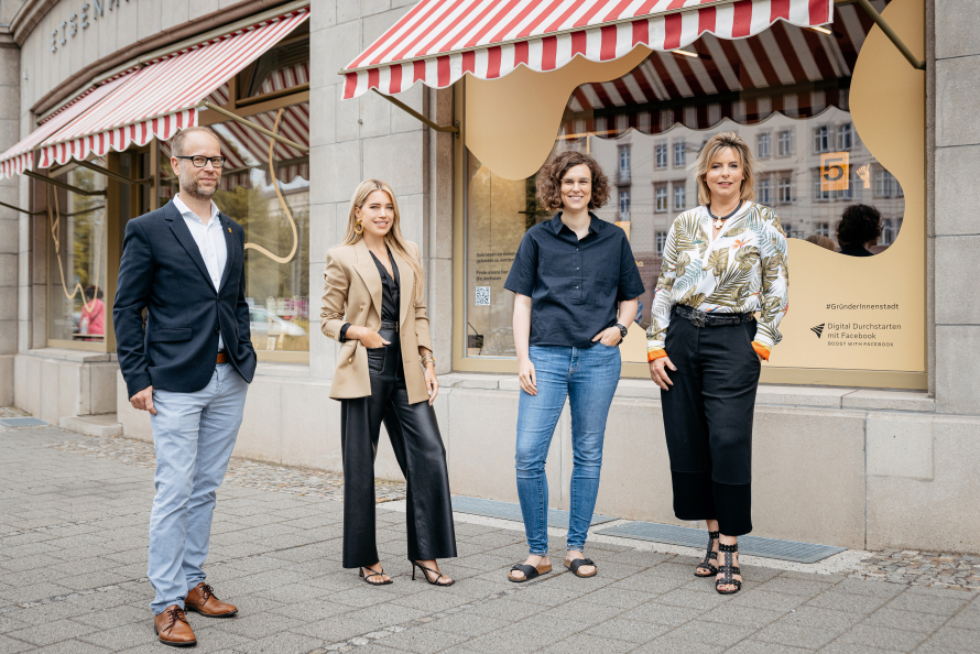 Four people standing outside a shop