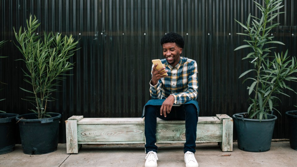 Image of man smiling at his phone