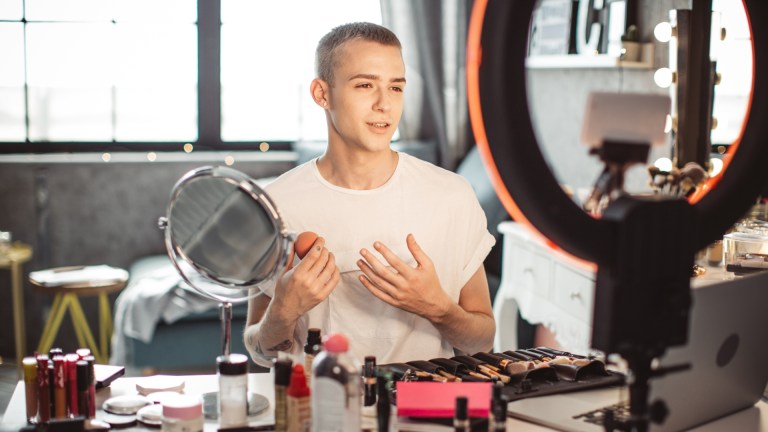 Photo of a creator filming a makeup demo
