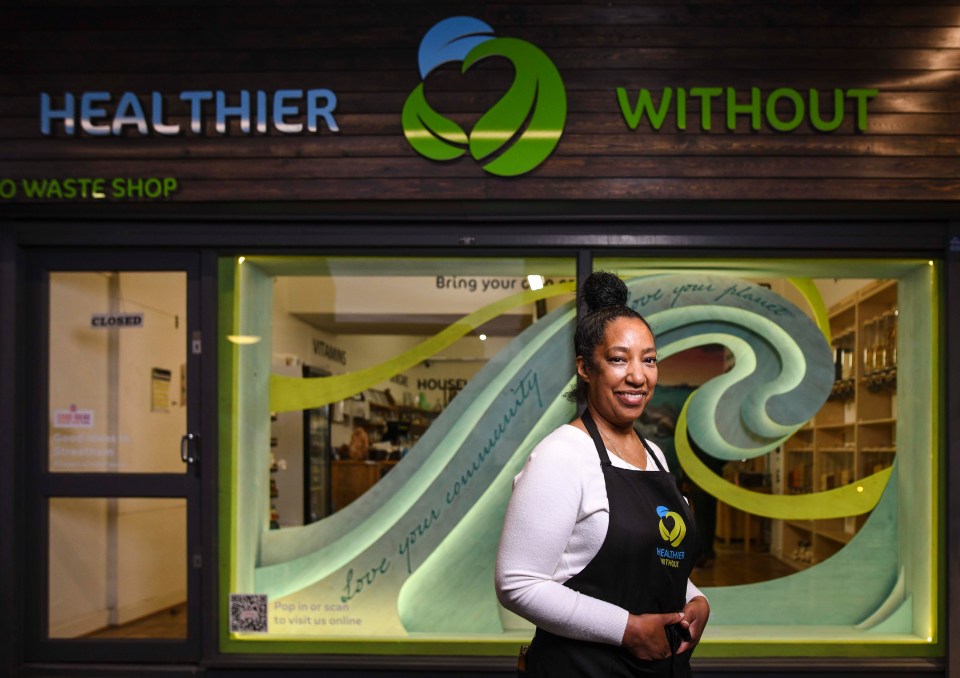 Female business owner standing in front of a shop window.