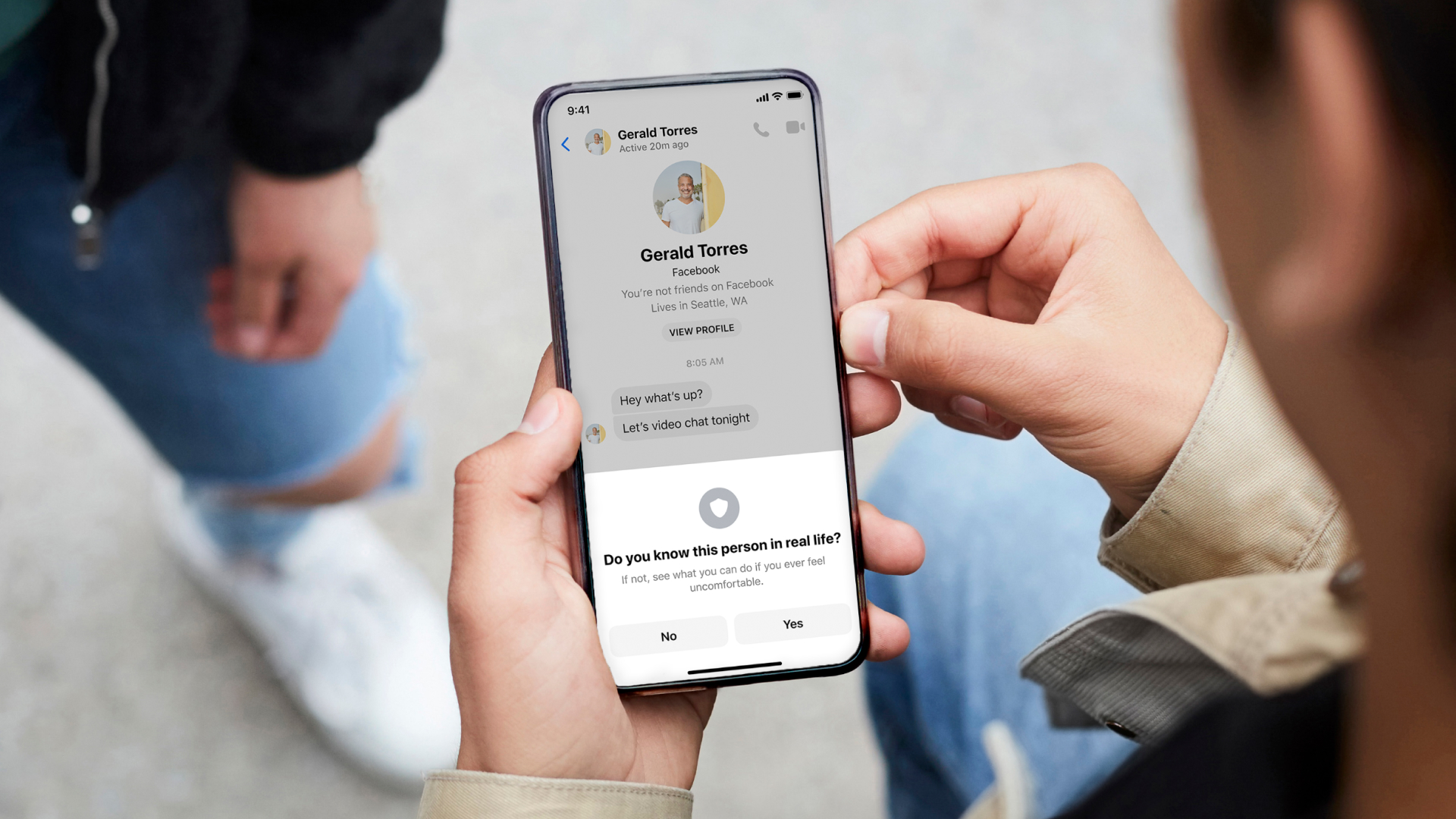Photo of teenager holding a phone and seeing privacy default warnings on Facebook