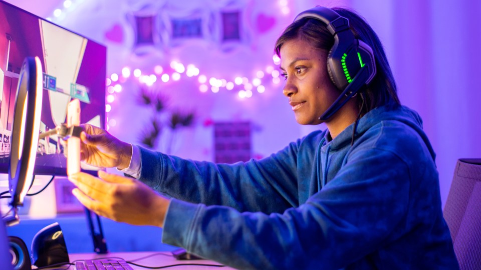Image of woman with headphones on adjusting her phone