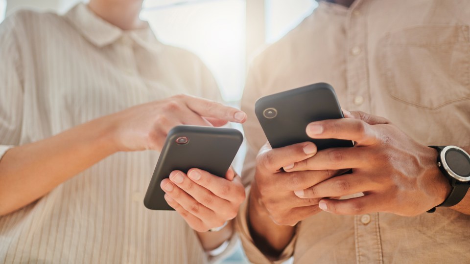 Photo of two people looking at their phones