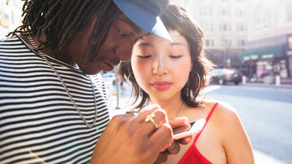 Photo of a man and a woman looking a phone