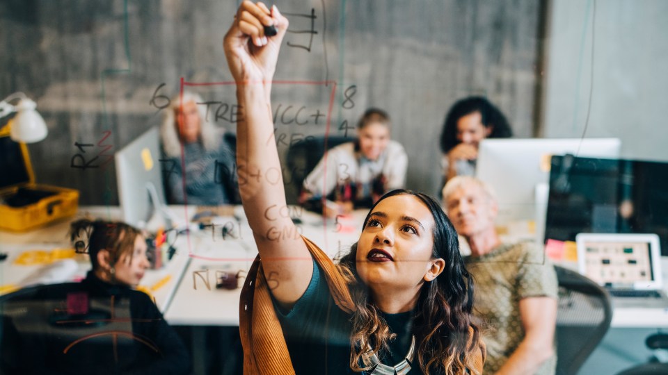 Photo of a team brainstorming and writing down ideas in an office