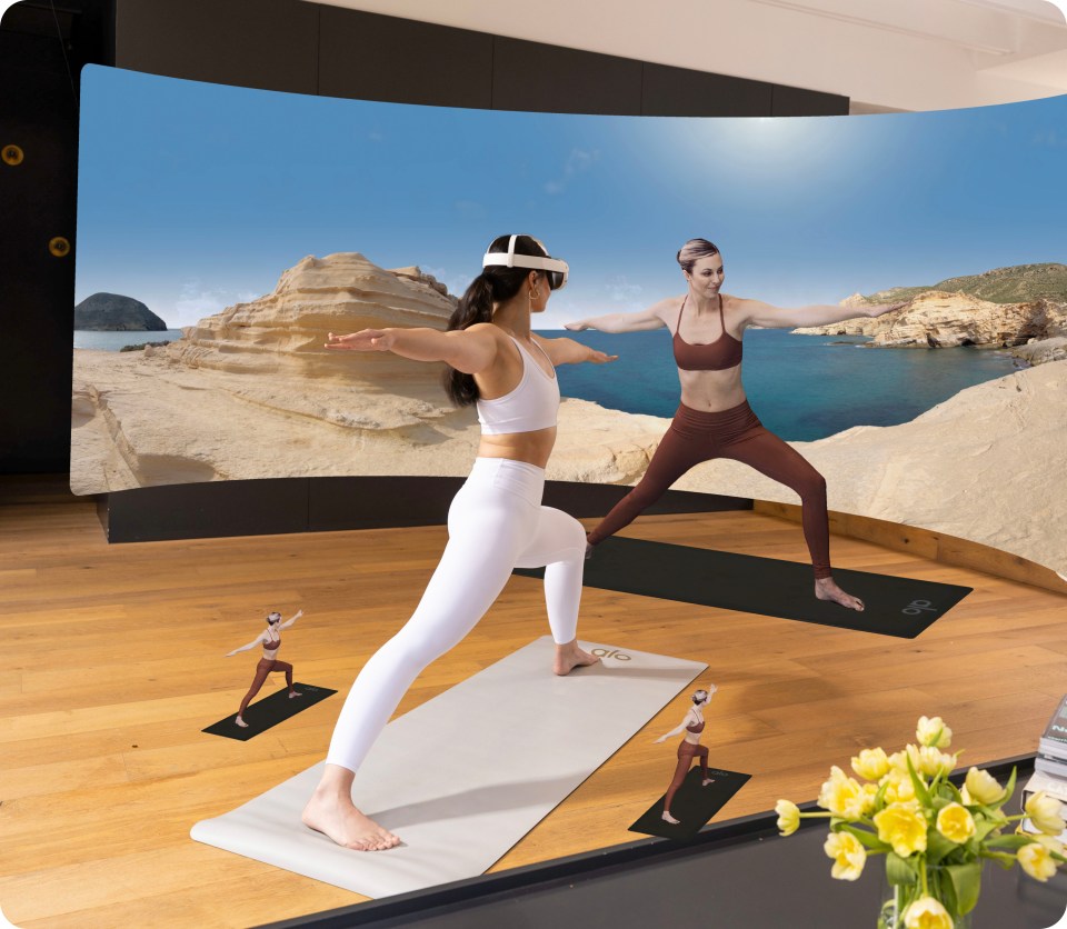 An image of a woman doing yoga in Alo Moves on Meta Quest 3, looking at an instructor with two "mini-instructors" beside her.