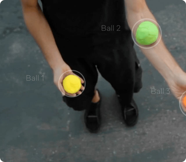 GIF of hands juggling balls, with SAM 2 highlighting and following the balls as they move